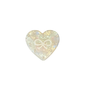 Support de téléphone élégant en forme de cœur avec nœud et strass sur fond blanc