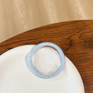 Close-up of a light blue round phone socket stand with glitter details on a white plate