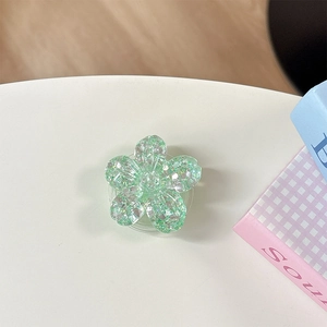 Dettaglio del supporto per telefono a fiore verde chiaro con paillettes scintillanti