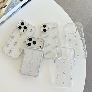 Transparent iPhone cases with glitter stars and silver rose designs on a white surface