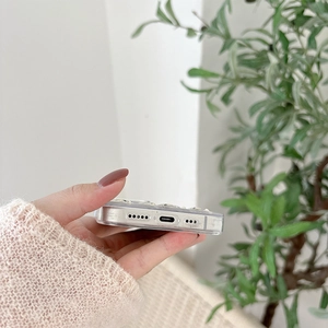 Close-up of clear glitter phone case showing precise speaker and charging port cutouts
