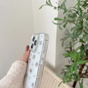 Detail of clear iPhone case featuring 3D silver stars and metallic rivet decorations