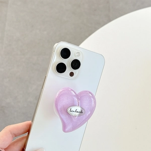 Purple glitter heart phone grip holder with handmade logo on a minimalist white desk