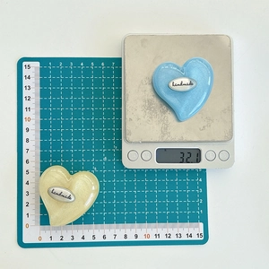 Macro detail of 5cm handmade heart-shaped phone grips with glitter resin finish