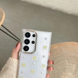 Detail of clear glitter phone case with yellow bows and silver camera frame for Samsung S25