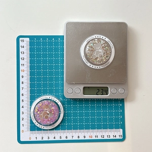 Detailed top view of a glitter bear magnetic phone grip on scale weighing 23.4 grams