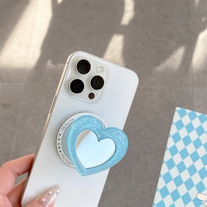 Close-up of glitter blue heart-shaped phone grip with a compact makeup mirror for phone