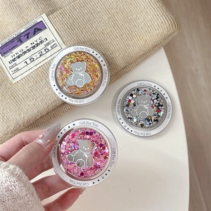Three magnetic glitter bear phone sockets in gold, pink and multi-color on a white table