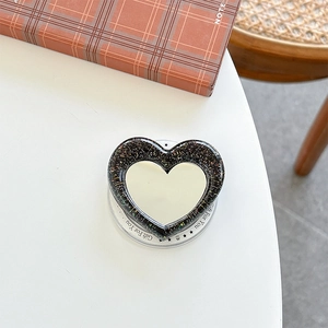 Macro view of heart-shaped glitter phone grip with makeup mirror and gift printed base