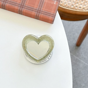 Detail of heart-shaped glitter phone grip featuring a compact mirror and gift text base