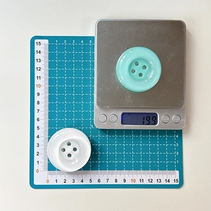 Detailed scale measurement showing 5cm diameter and 19.9g weight of mint button phone stand