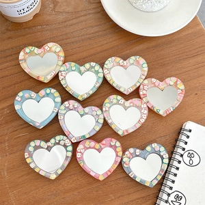 Close-up of heart-shaped glitter phone grips with colorful fruit resin patterns