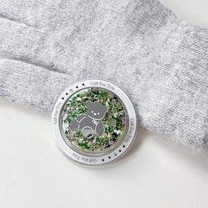 Macro detail of a magnetic glitter bear phone socket with green flowing sand effect