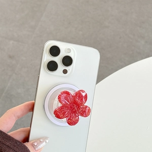 Detail of red glitter flower phone grip socket mounted on a white smartphone