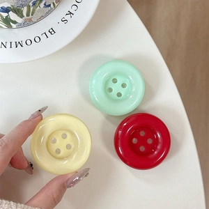 Colorful large button phone socket stand in mint green, pale yellow, and vibrant red colors
