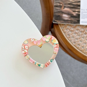 Macro shot of heart-shaped glitter mirror phone grip with fruit resin decorations