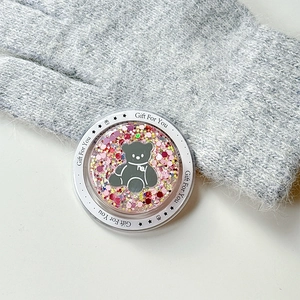 Detail of glitter pink phone griptok featuring a gray bear and Gift For You text