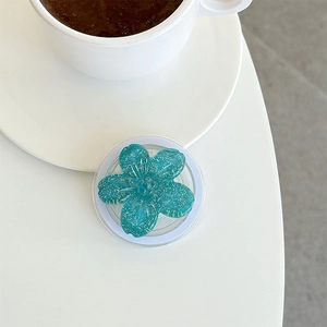 Close-up of a floral glitter phone socket on a desk with a coffee cup in the background