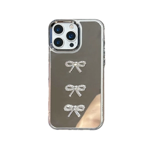 Mirror phone case for iPhone with three sparkling rhinestone bowknot accents on silver back