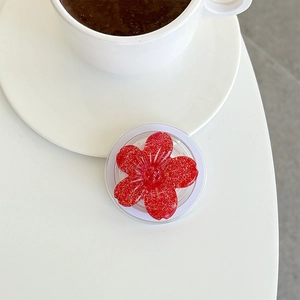 Macro shot of a red glitter resin flower phone socket on a white minimalist desk