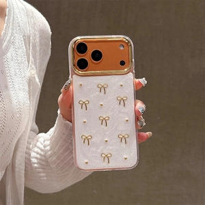Detail of white textured iPhone case with 3D gold bow rivets and metallic camera frame