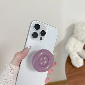 Purple button cell phone grip stand on white smartphone in a cozy home setting