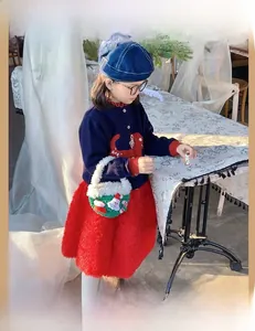 Toddler wearing a green handmade crochet Christmas bag with 3D Santa and candy cane patches