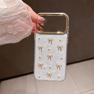 Detail of iPhone case with 3D gold bows and pearls featuring a glossy white finish