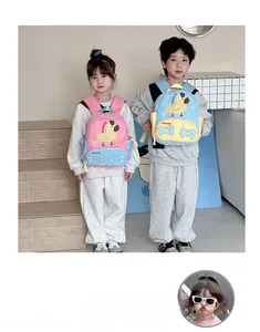 Toddlers wearing cute yellow duck backpacks in pink and blue colors on indoor steps