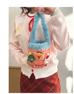 Close-up of handmade crochet bag with plush handles and festive Christmas ornaments