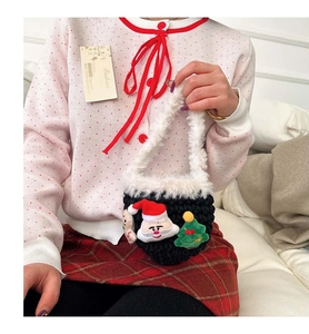 Close-up of handmade crochet bag with plush Santa and gingerbread man decorations