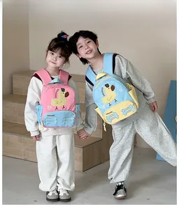 Detail view of cute cartoon duck backpack on kids in a minimalist indoor setting