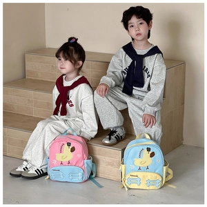 Detailed view of kids cartoon duck backpacks in pink and blue colors on stairs