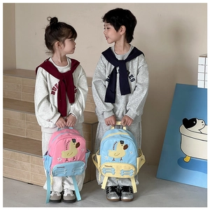Toddlers in grey tracksuits with pink and sky blue cartoon duck backpacks on stairs