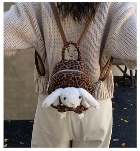 Detail of cute leopard print plush backpack featuring a 3D bunny on a child model back