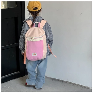 Close-up of pink children's backpack with durable canvas texture and brand patch