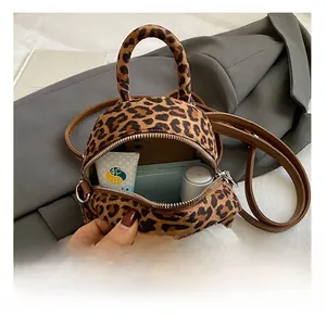Internal storage detail of leopard print plush backpack with mini doll charm