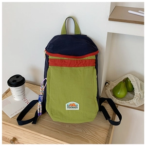 Close-up of color-block backpack with green canvas and blue top handle for kids