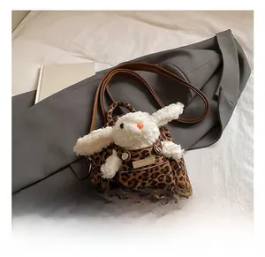 Detail of leopard print mini backpack with white plush bunny and brown shoulder strap