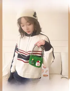 Detail of green handmade crochet kids bag with 3D Santa and silver bead handle