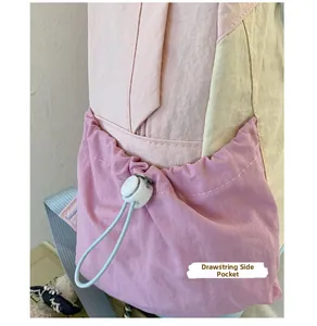 Close-up of drawstring side pocket on a pink and beige nylon school backpack