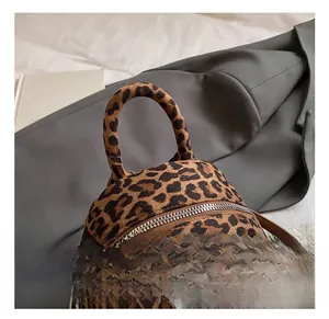 Close-up of leopard print plush mini backpack with round handle and metal zipper