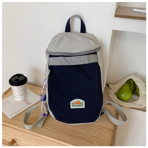 Detail view of a minimalist two-tone kids backpack with mountain patch and woven rope