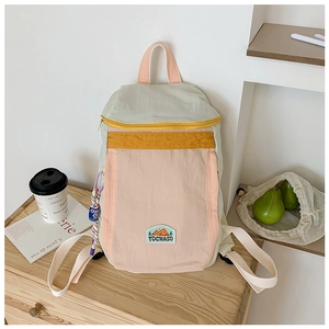 Detail of color-block kids backpack featuring mountain patch and mint green accents