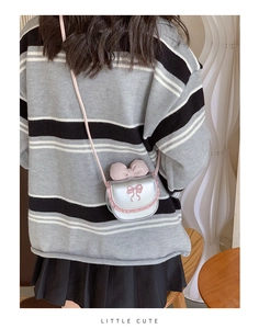 Close-up of silver mini bag featuring a pink bow, lace edges, and 'LITTLE CUTE' text