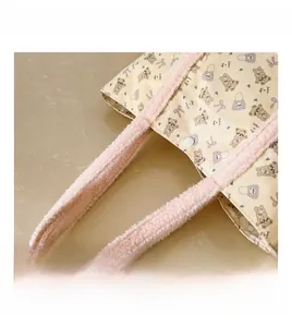 Detail of plush pink handle and canvas fabric on kids' cute bear crossbody bag