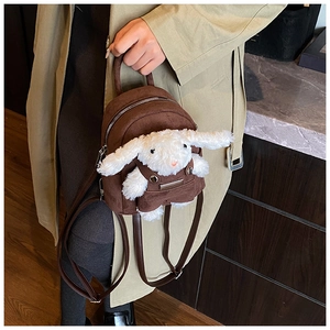 Close-up of mini brown suede backpack with cute plush bunny doll decoration