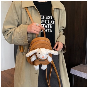 Detailed shot of kids brown suede backpack with cute plush bunny doll and adjustable straps