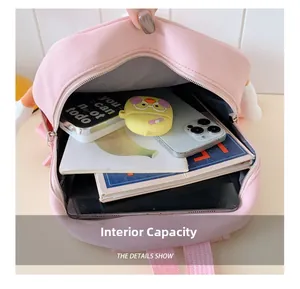 Detailed view of large internal capacity for school supplies in a pink canvas backpack