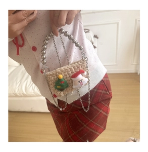 Close-up of knit Christmas mini bag with Santa applique and beaded handle strap